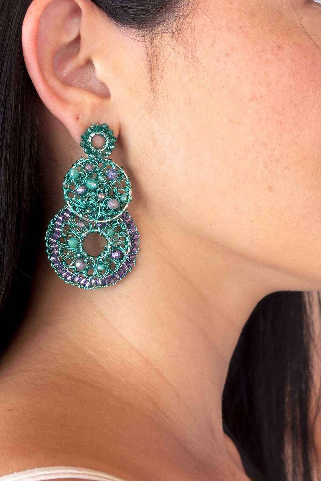Pair of green beaded earrings on a white background