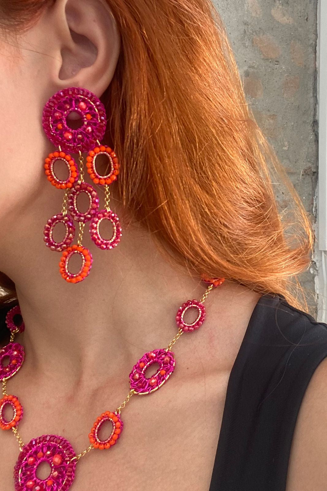 Pair of red and orange beaded earrings on a white background