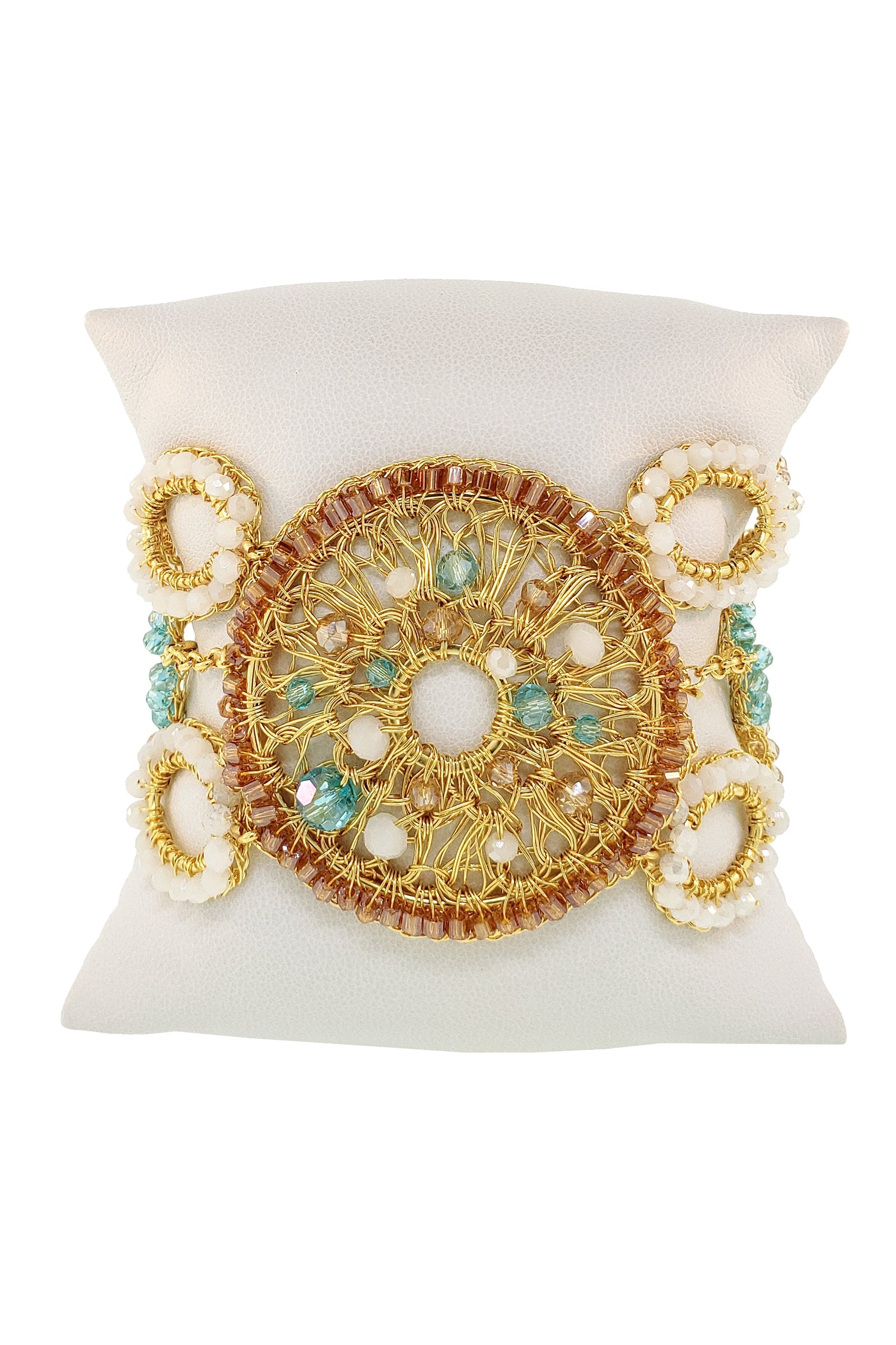 Gold bracelet with intricate design and green gemstones on a white background