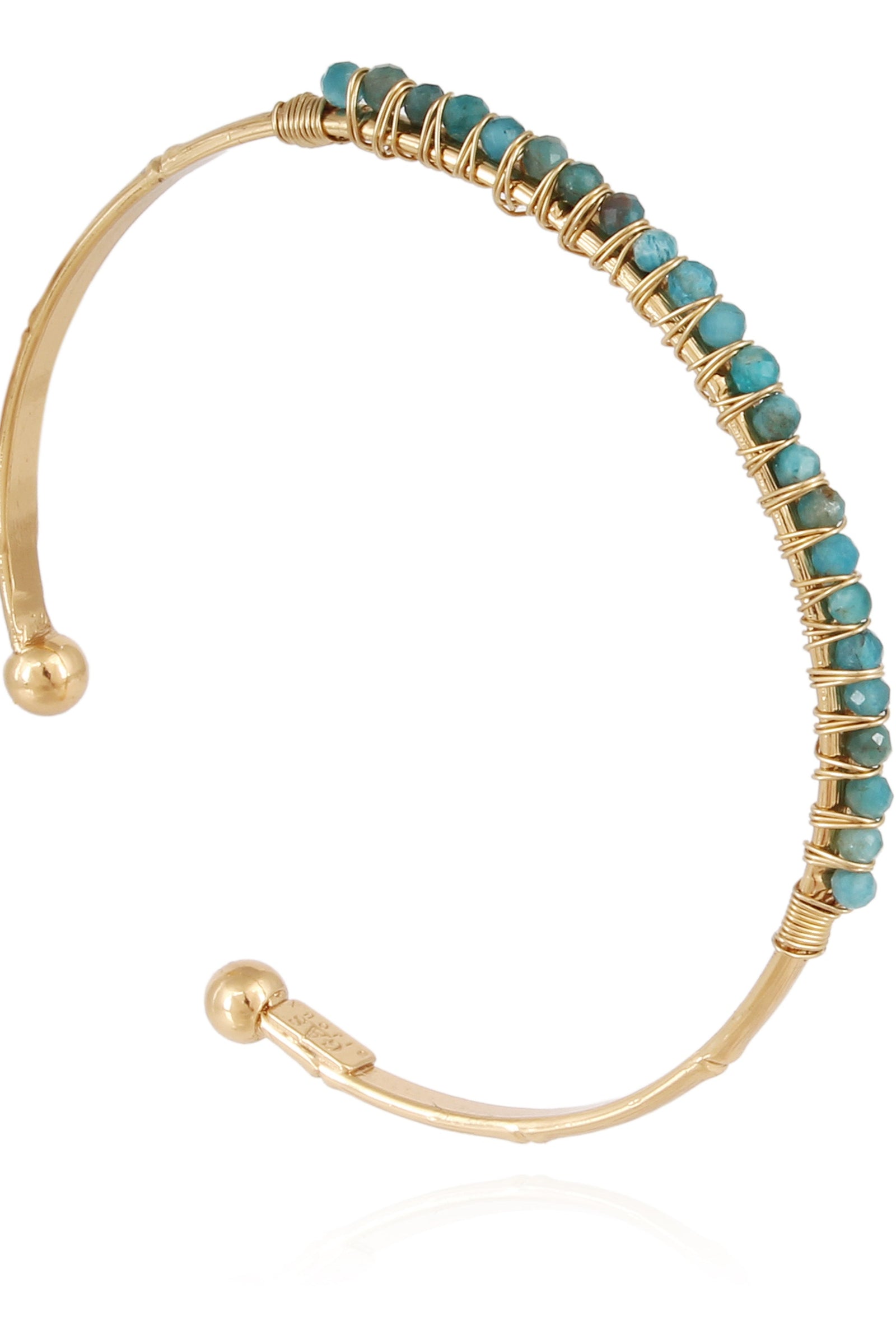 A gold-colored bracelet with turquoise stones arranged in a pattern along its length.