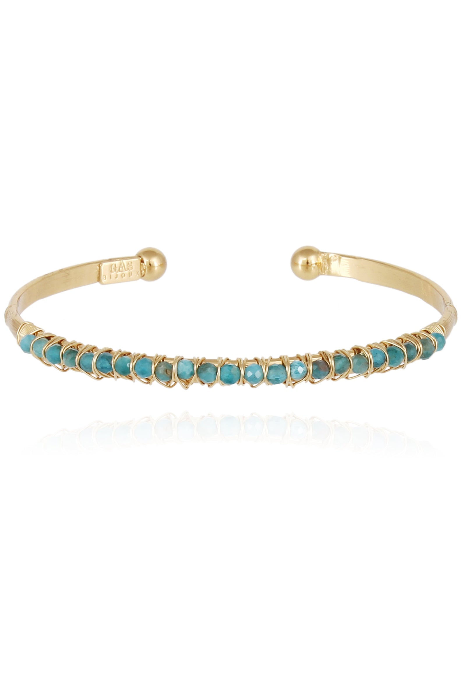 A gold-colored bracelet with turquoise stones arranged in a pattern along its length.