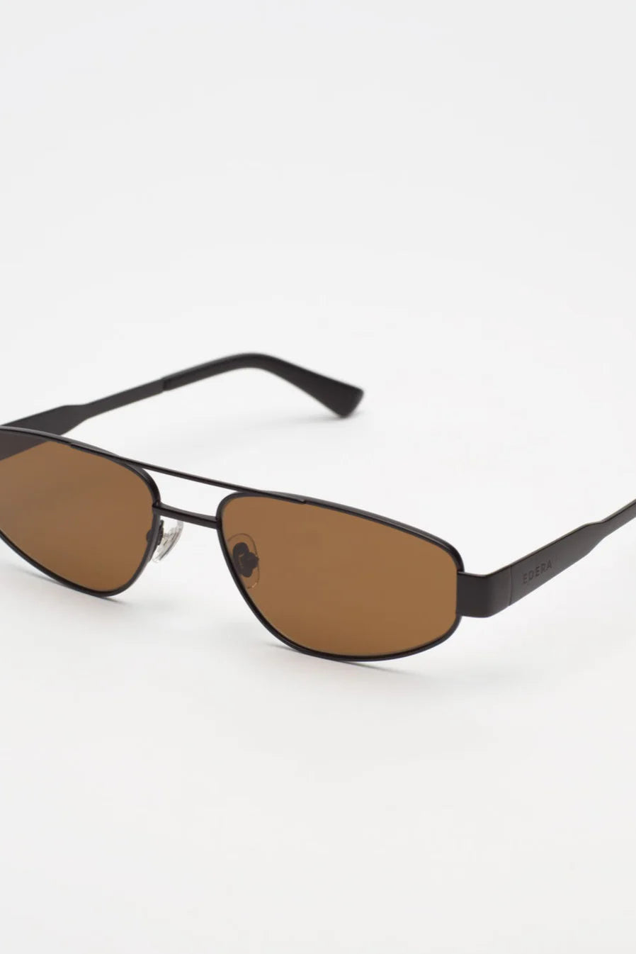 Black sunglasses with brown lenses on a white background