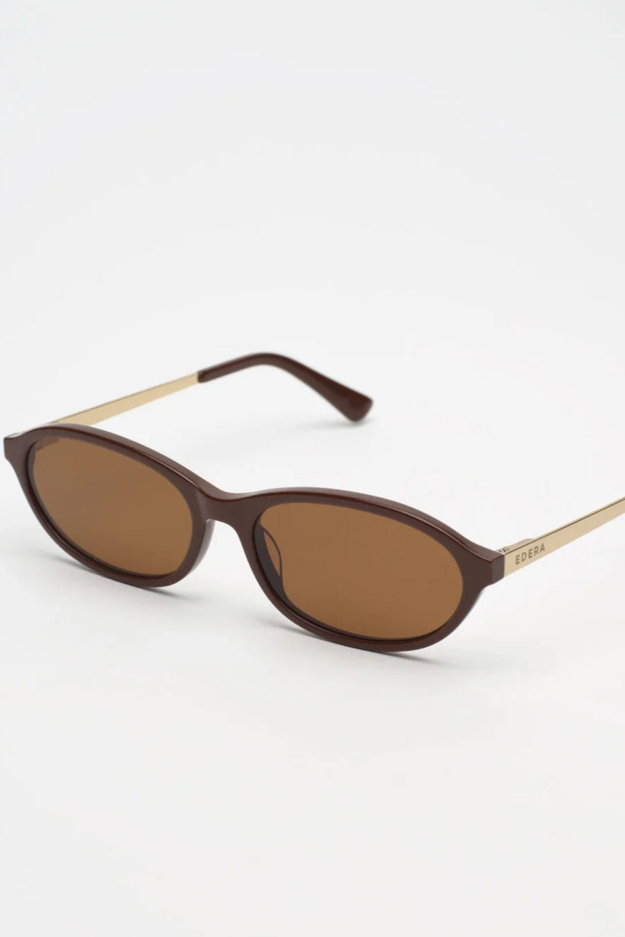 Sunglasses with brown lenses and gold frames on a white background