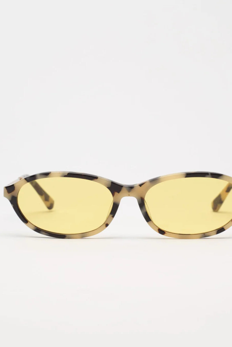 Sunglasses with yellow lenses and tortoiseshell frame on a white background