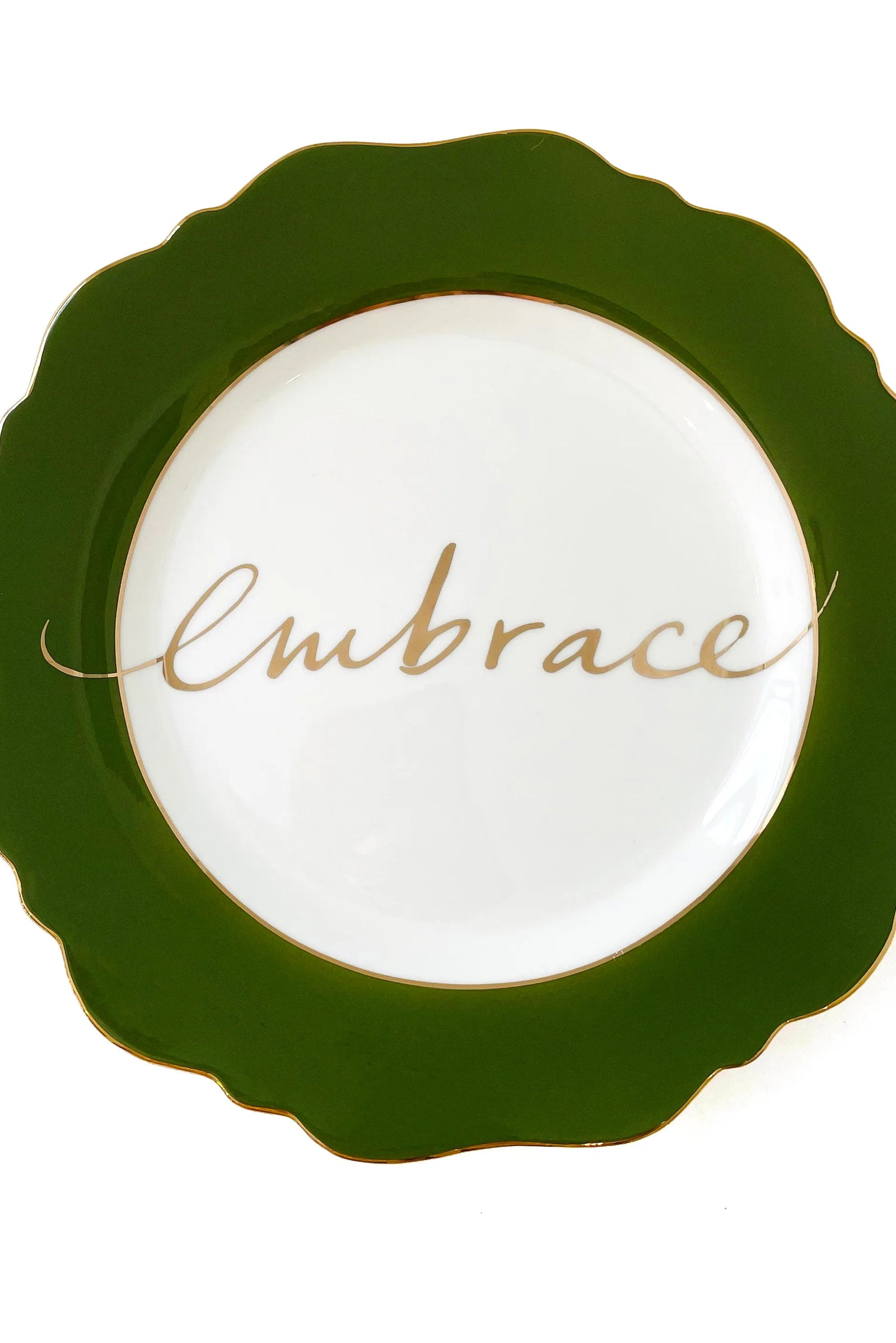 An olive green side plate with the word 'Embrace' written in the center, trimmed in 24-carat gold.