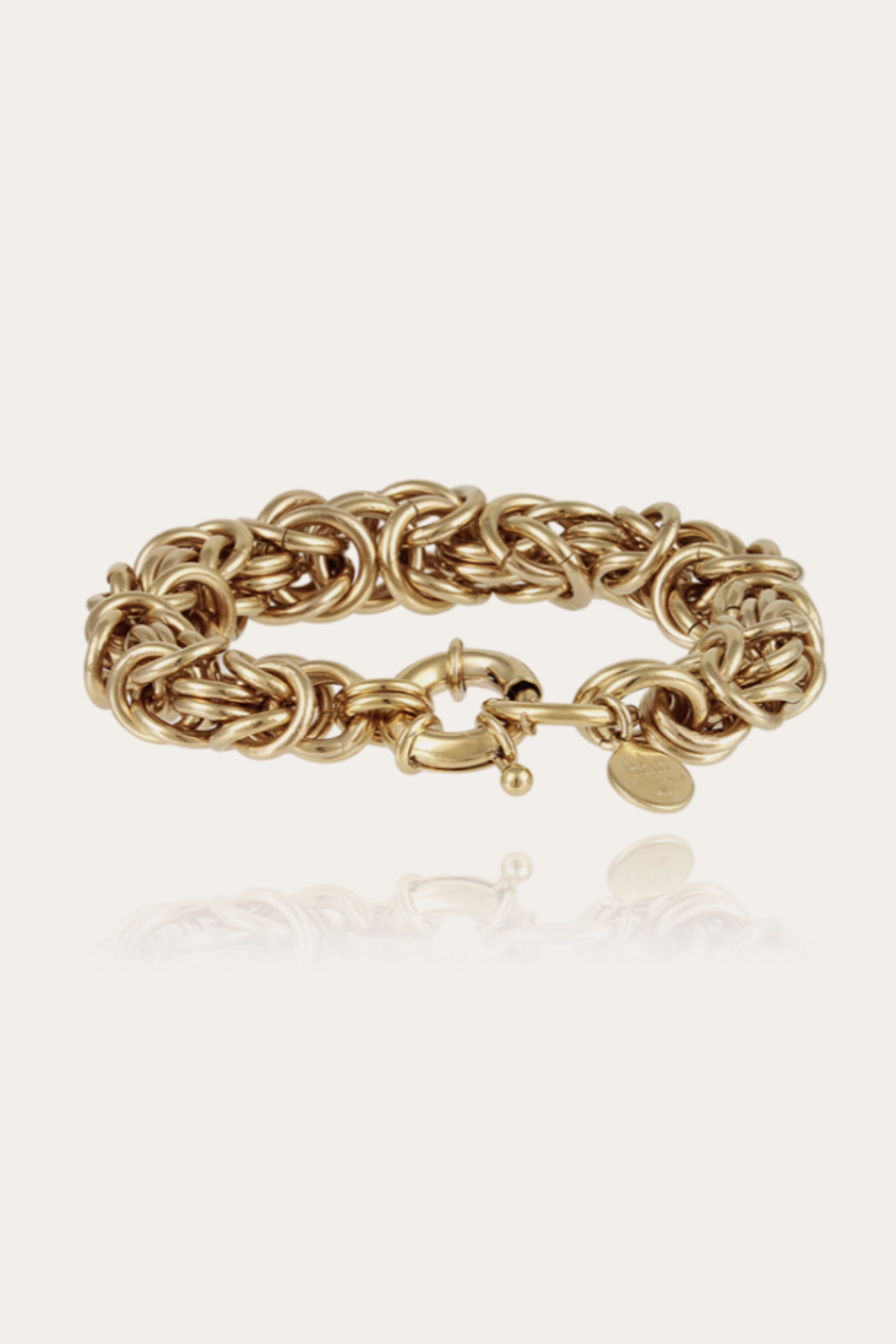 A gold-colored bracelet with a textured, possibly chain-link pattern.