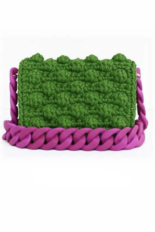 Green textured pouch with purple braided handle on a white background