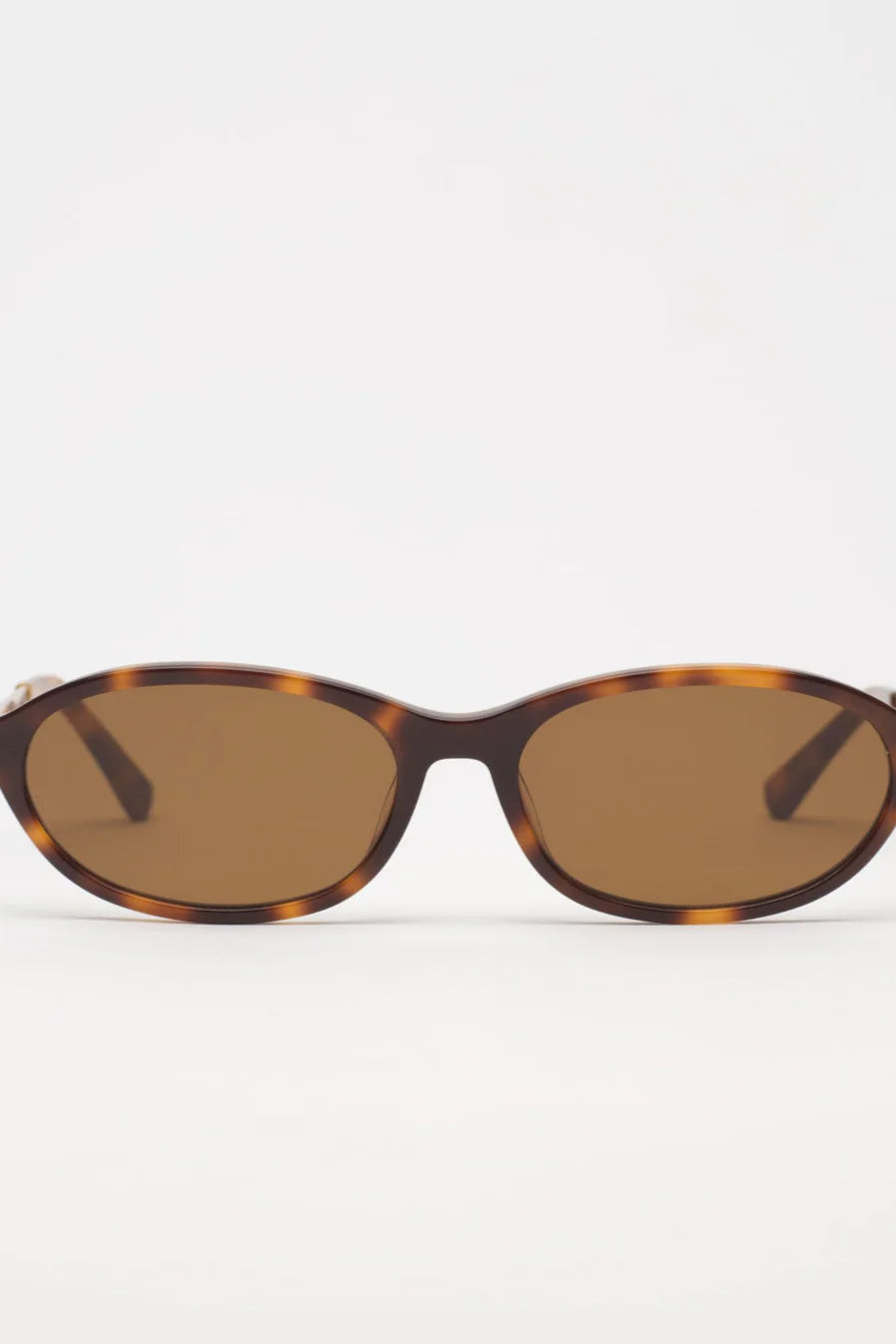 Sunglasses with tortoiseshell frame and brown lenses on a white background