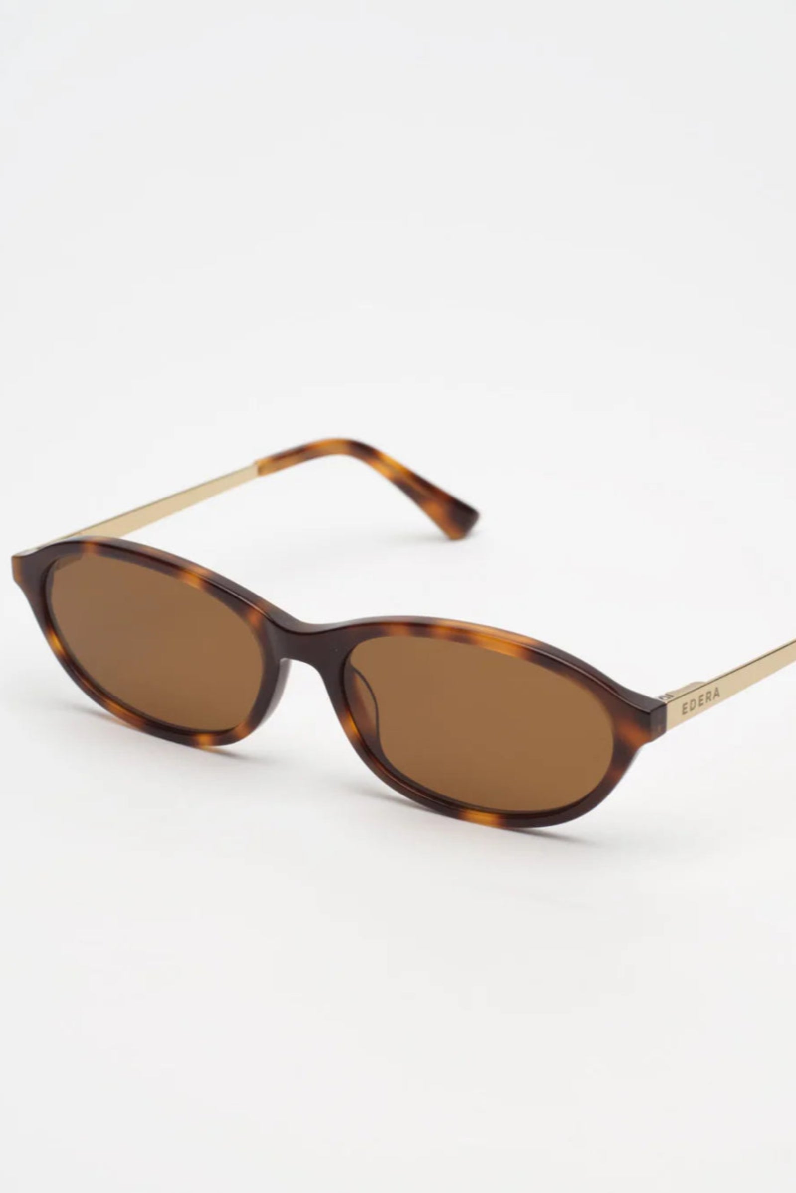 Sunglasses with tortoiseshell frame and brown lenses on a white background