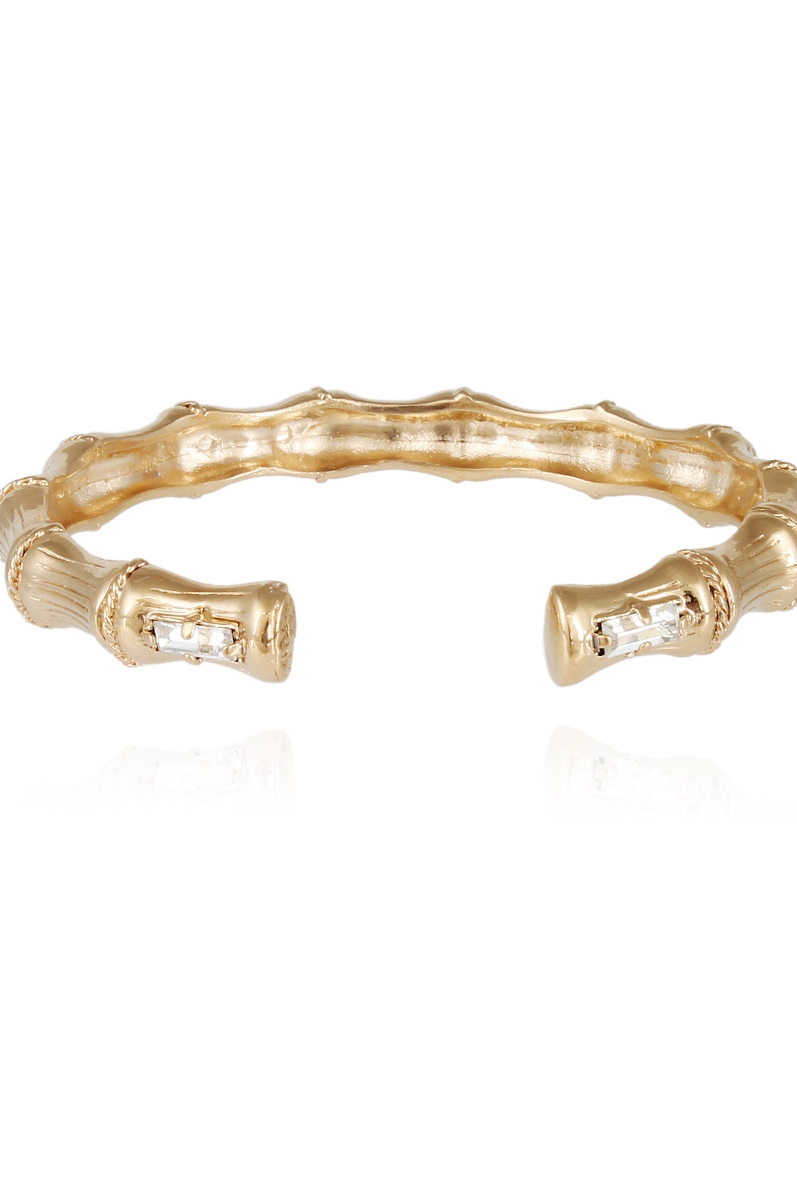 A gold-colored bamboo design bracelet with strass (clear crystals) accents.