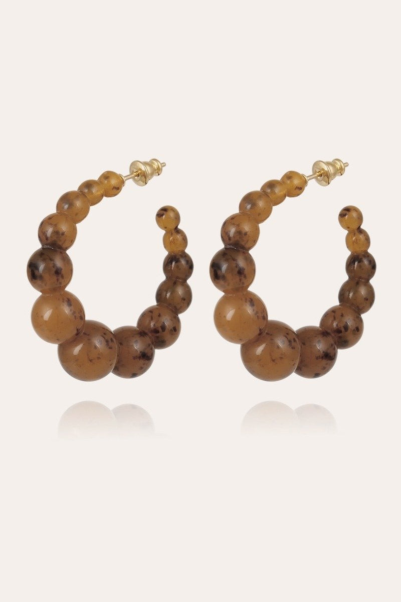 Pair of brown beaded hoop earrings on a light gray background