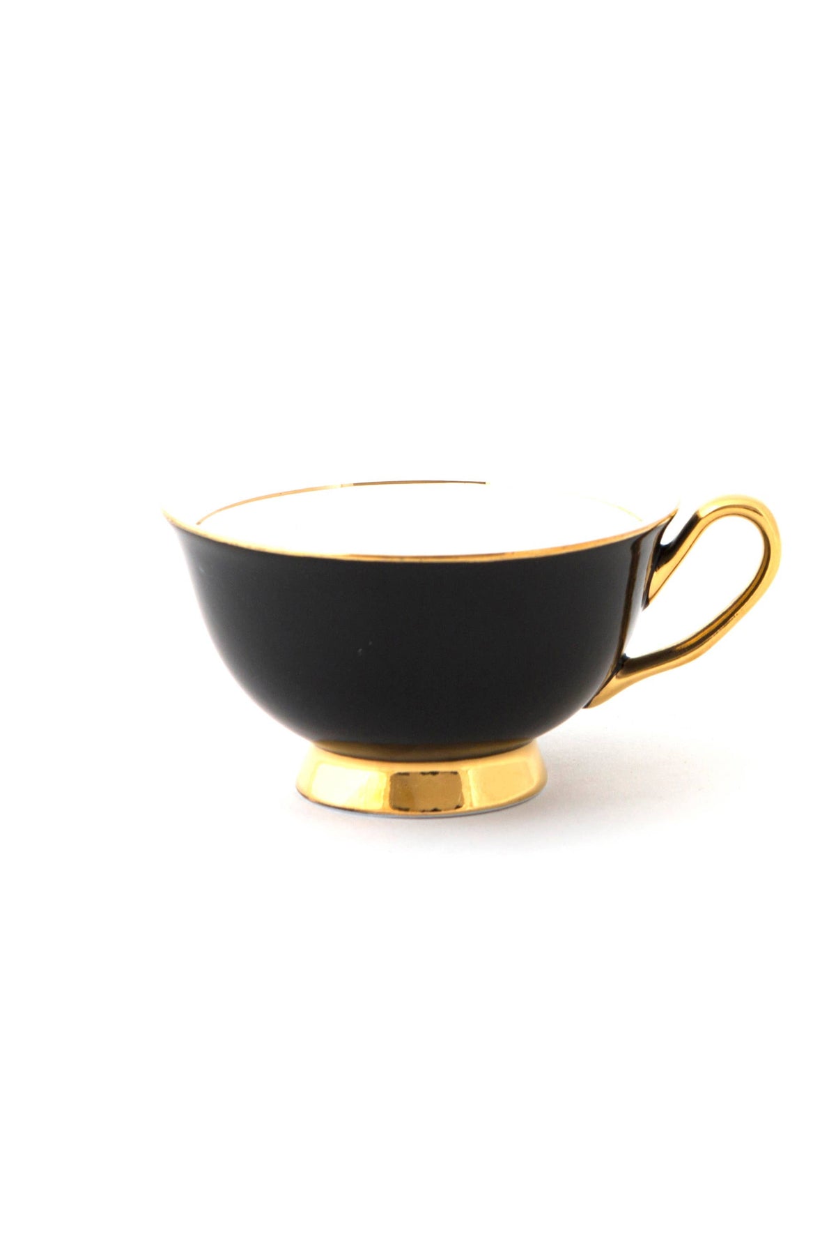 Black teacup with gold trim on a white background